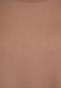 Rustfarvet, letvægtsstof med en glat tekstur, der har rund halsudskæring og korte ærmer. Enkel og minimalistisk design.