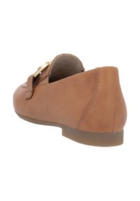Scarpa in cuoio tan con punta arrotondata, tacco basso, dettaglio con fibbia laterale e texture liscia, che mette in mostra un design minimalista e una lavorazione artigianale.