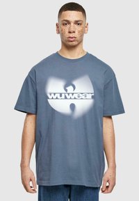 Sivý bavlnený tričko s veľkým bielym a sivým logom Wu Wear, krátke rukávy, okrúhly výstrih a voľný strih. Textúrovaný povrch a bez vzorov.
