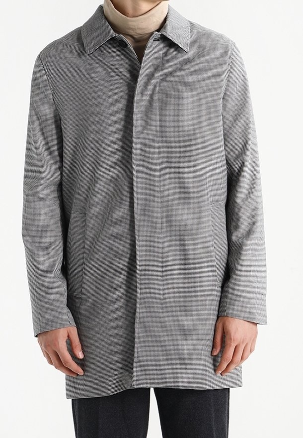 Manteau à carreaux gris et blanc avec col cranté, manches longues et silhouette droite avec poches latérales. Tissu lisse et léger.