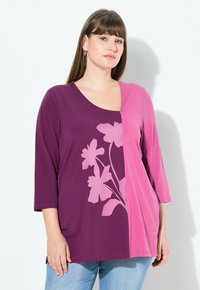 Top in paars en roze met driekwartmouwen, een bloemenontwerp in lichtroze en een ronde halslijn. Zachte, gladde textuur.