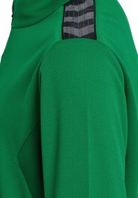 Groene fleece pullover van een gestructureerde, ademende stof. Beschikt over een zijpaneel van zwart met patroon op de schouder.