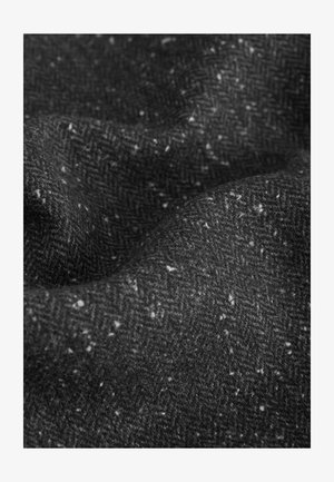 Houndstooth-patterned fabric in black with gray and white speckles, made of a coarse wool blend, featuring a soft, textured surface.