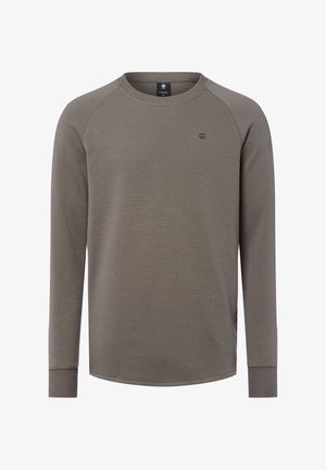 Graues Langarmshirt mit einer strukturierten Waffeloptik, geripptem Rundhalsausschnitt und figurnahen Bündchen. Verfügt über ein kleines Logo auf der Brust.