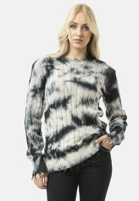 Black and white tie-dye sweater with ribbed texture, frayed hems, and long sleeves. Features a crew neckline and cable knit pattern.