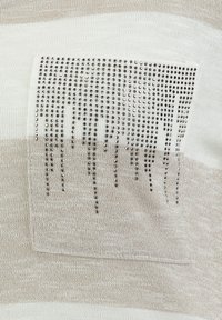 Gestreiftes Strickoberteil in Beige und Creme, mit einer strukturierten Tasche versehen, die mit silbernen Strasssteinen dekoriert ist und dem Design Detail und Dimension verleiht.