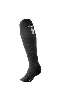 Calza a compressione nera con texture a coste, design fino al ginocchio e punta rinforzata. Presenta un logo e dettagli bianchi sui lati.