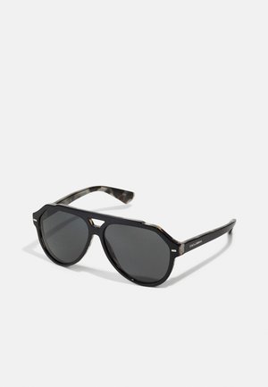 Óculos de sol pretos em forma octogonal com lentes escuras, apresentando uma haste em padrão tartaruga e subtis detalhes metálicos para um visual distintivo.