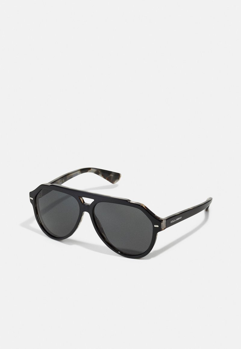 Ochelari de soare octagonali negri cu lentile întunecate, având un brad din țestoasă cu un model și accente metalice subtile pentru un aspect distinctiv.