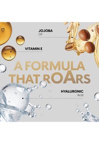 Gouden oliedruppels met het label Vitamine E en Jojoba-olie, heldere waterbubbels met het label Hyaluronzuur, met de tekst "Een formule die brult" in goud.