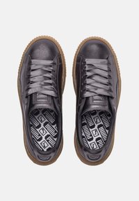 Baskets en cuir gris à finition lisse, lacets plats et semelle en caoutchouc gomme. L'intérieur présente une semelle intérieure à motif avec le logo de la marque.