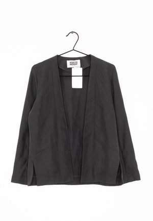 Blazer noir à devant ouvert avec manches longues suspendu sur un cintre noir sur fond blanc.