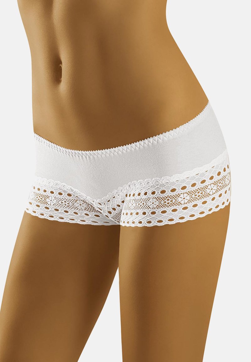 Un short blanc en tissu doux avec un ourlet en dentelle aux motifs découpés et aux bords festonnés, offrant un design détaillé et texturé.