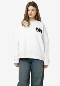 Witte oversized sweatshirt met ribgebreide manchetten en zoom, voorzien van een zwart "NM" logo op de linkerborst. Gleedachtige textuur, casual pasvorm.