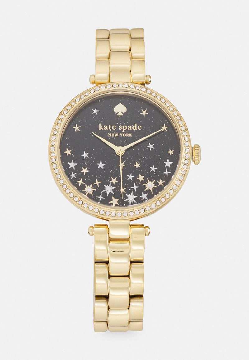 Gold-tone watch with a black starry dial, featuring silver and gold stars, and a crystal-accented bezel. Linked bracelet style band.