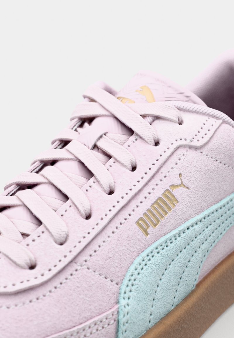 Sneaker in suede rosa chiaro con una striscia verde menta, logo dorato e lacci piatti; presenta dettagli testurizzati e suola in gomma.