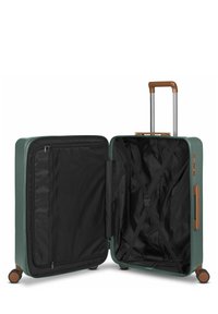 Valigia rigida verde con manico marrone, sistema trolley argentato e interno nero. Presenta cinture a forma di X e una tasca con zip all'interno.