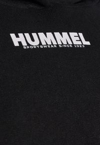 Zwarte sweatshirt met een witte "HUMMEL" logo en de tekst "SPORTSWEAR SINCE 1923", van een textuurstof en met een capuchon.
