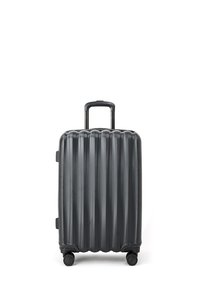 Walizka twarda w ciemnoszarym kolorze z pionowym żebrowanym wzorem, z teleskopową rączką i czterema kółkami zapewniającymi łatwość w poruszaniu się.