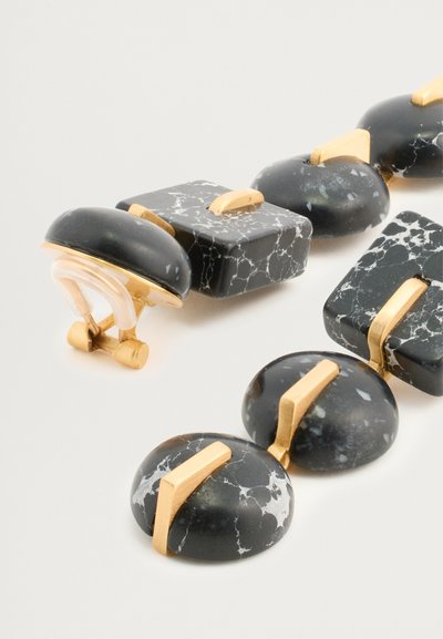 Collana nera e oro caratterizzata da perle a forma rotonda e quadrata simili al marmo, con venature bianche e dettagli dorati, progettata con un gancio di chiusura.