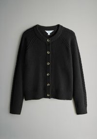 Musta neulottu neuletakki pyöreällä kaula-aukolla, edessä napillinen suljenta, resorireunukset helmassa ja hihansuissa, teksturoidulla kankaalla ja hihoissa olevilla palmikkoneulekuvioilla.