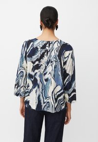 Blusa ampia con un motivo marmorizzato nei toni del blu navy, bianco e teal. Presenta maniche a tre quarti e un collo arrotondato.