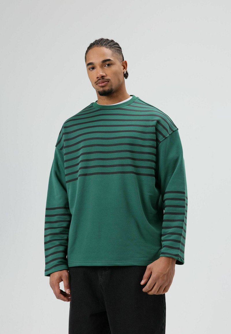 Groene lange mouwshirt met zwarte horizontale strepen, ronde halslijn en een losse pasvorm. Gemaakt van zachte stof met een gladde textuur.