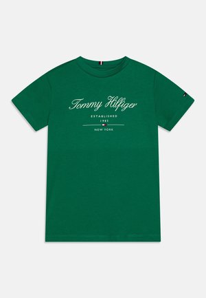 Zielona koszulka z krótkim rękawem i okrągłym dekoltem, z napisem "Tommy Hilfiger Established 1985 New York" oraz małym logo flagi z przodu i na rękawie.