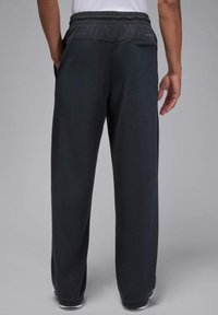 Donkergrijze sweatpants voor heren met een losse pasvorm, elastische tailleband en een achterzak. De stof lijkt zacht met een gladde textuur.