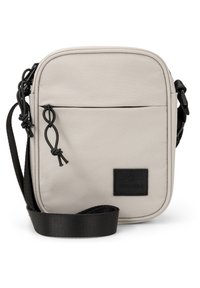 Borsa a tracolla in poliestere beige con tasca frontale con zip, tracolla nera e patch con logo. Presenta una forma rettangolare e una texture liscia.