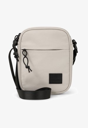 Beige polyester crossbody bag with a front zip pocket, black strap, and logo patch. Features a rectangular shape and smooth texture.
