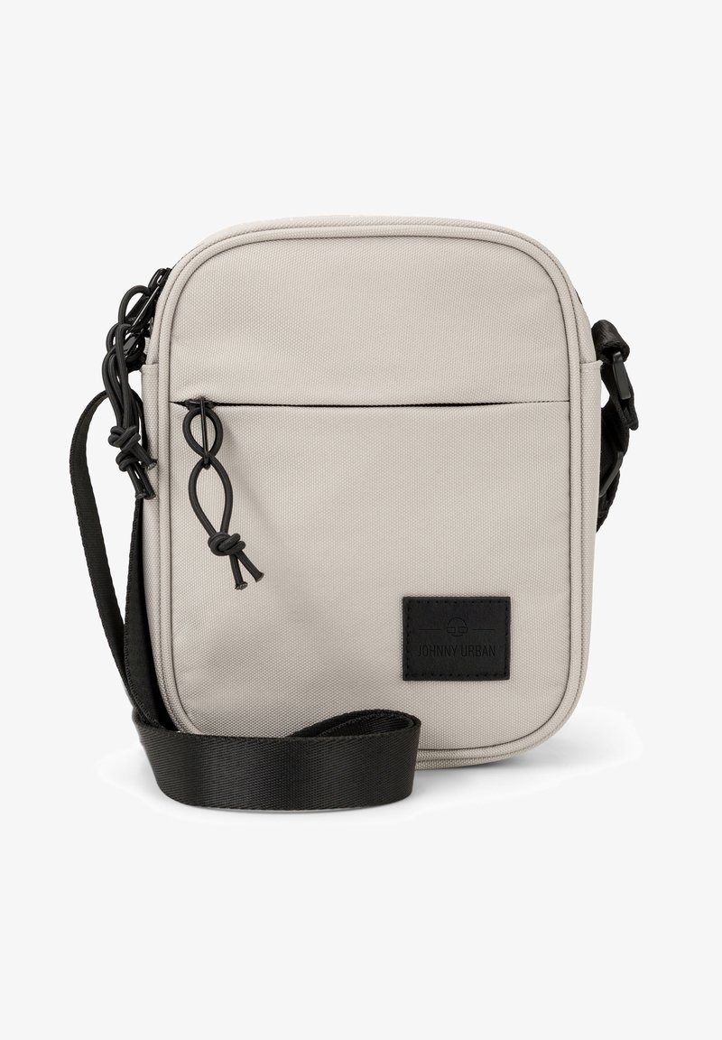 Borsa a tracolla in poliestere beige con tasca frontale con zip, tracolla nera e patch con logo. Presenta una forma rettangolare e una texture liscia.