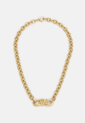 Collana in metallo dorato con grandi anelli ovali, caratterizzata da un dettaglio a nodo decorativo con piccoli accenti trasparenti vicino al gancio.