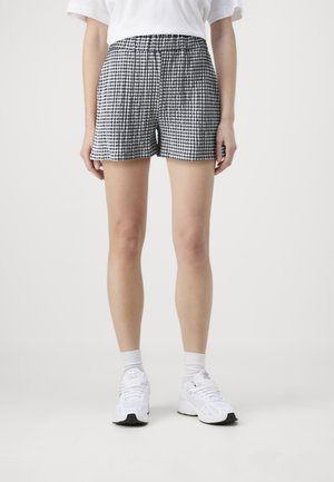 Shorts à carreaux noir et blanc avec une taille élastique, fabriqués dans un tissu léger, offrant une coupe décontractée et un ourlet plat.