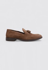 Mocasines de ante marrón con un detalle de borlas, textura suave, tacón bajo y costuras en la parte superior y los lados.