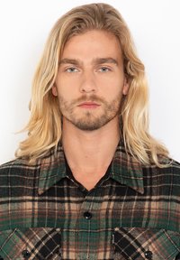 Flannel skjorte med et grønt, brunt og sort rutemønster. Har sorte knapper og to brystlommer. Blød tekstur og klassisk kravedesign.