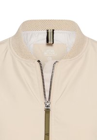 Beige bomberjack met een textuurkraag, zilveren rits en groene accent trekker. Gemaakt van glad, lichtgewicht materiaal en voorzien van een logo-label.