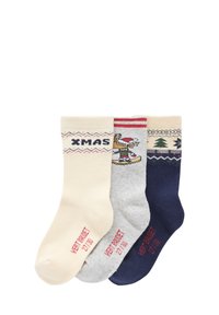 Three pairs of knitted socks: cream with "XMAS," grey with a character design, and navy with a tree pattern, all featuring ribbed cuffs.