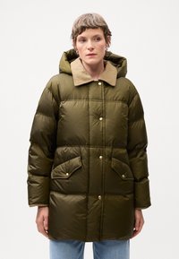 Geacă pufoasă de culoare verde măsliniu, cu un guler bej, ce prezintă nasturi pe față și două buzunare mari tip patch. Materialul are o textură netedă și lucioasă, cu un aspect pufos.