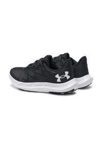 Zapatillas deportivas negras con suelas blancas y el logo de Under Armour en los lados, con tejido de malla texturizada y diseño de cordones.