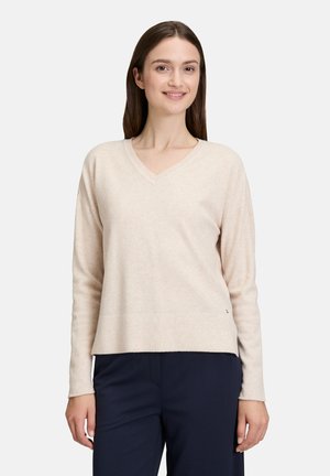 Pull col v beige clair à manches longues, en tissu tricot doux. Présente un ourlet droit et une texture légèrement extensible.