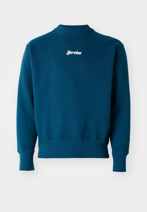 Teal sweatshirt with ribbed cuffs and hem, featuring a white embroidered "Service" logo on the upper back. Soft texture and crew neck design.