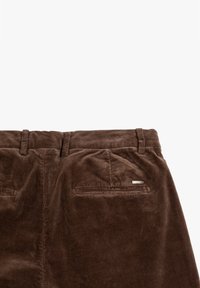 Bruine corduroy broek met een gladde textuur, rechte pijpen en twee achterzakken met een klein metalen label.