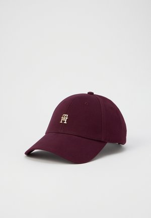 Tummanpunainen puuvillapohjainen baseball-lakki, jossa on kullalla brodeerattu logo. Lakissa on kaareva lippa ja kahdeksan paneelin muotoilu, sekä säädettävä hihna takana.