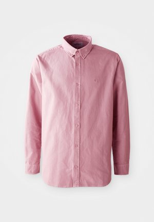 Srajca z dolgimi rokavi, z gumbi, v svetlo roza tkanini. Ima klasičen ovratnik, šest gumbov na sprednji strani in subtilno logotip na prsih.