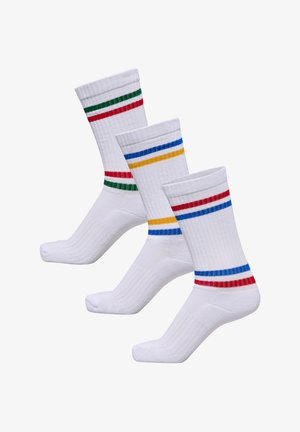 Trois paires de chaussettes blanches à rayures colorées : vert/rouge, bleu/jaune et rouge/bleu. Fabriquées en coton côtelé. Design athlétique classique.