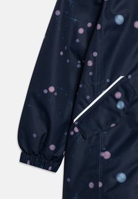 Marine jas met een hemels patroon van roze en blauwe cirkels, met elastische manchetten en een zijzak omlijnd in het wit.
