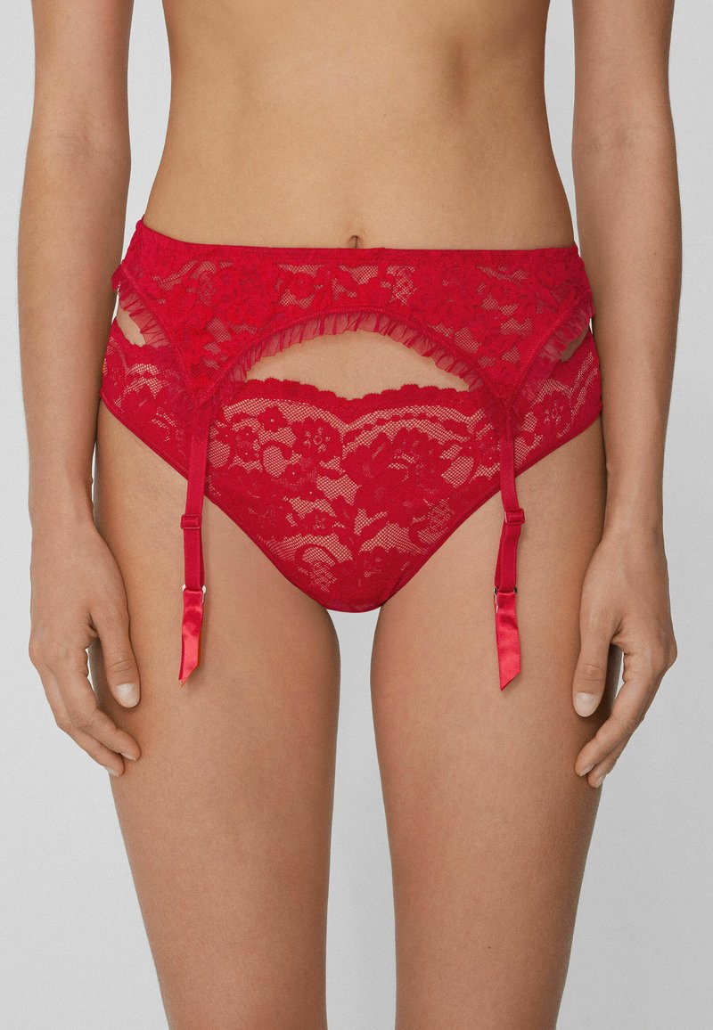 Rote Spitzenunterwäsche mit Rüschen, Aussparungen und Satinakzenten. Mit verstellbaren Trägern für eine optimale Passform. Weicher, transparenter Stoff.