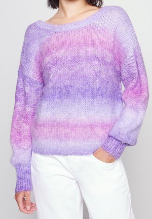 Gebreide trui in gradient tinten paars en roze, met een brede halslijn en geribde manchetten. Zachte textuur en een losse pasvorm. Gecombineerd met witte broek.