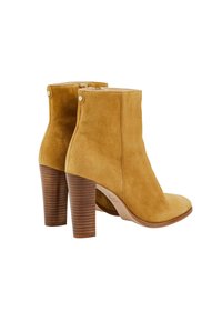 Bottines en daim camel avec talons blocs empilés en bois, bouts arrondis et fermetures éclair latérales, vues de dos et de côté.